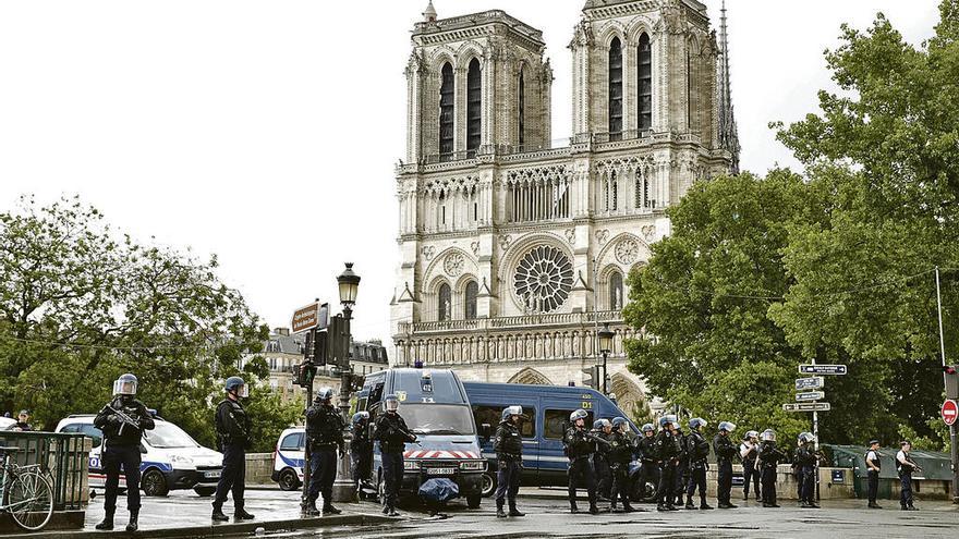 Despliegue policial en torno a la capital parisina tras el atentado. En el recuadro, el terrorista en el suelo y un agente apuntándole. // Efe/Reuters