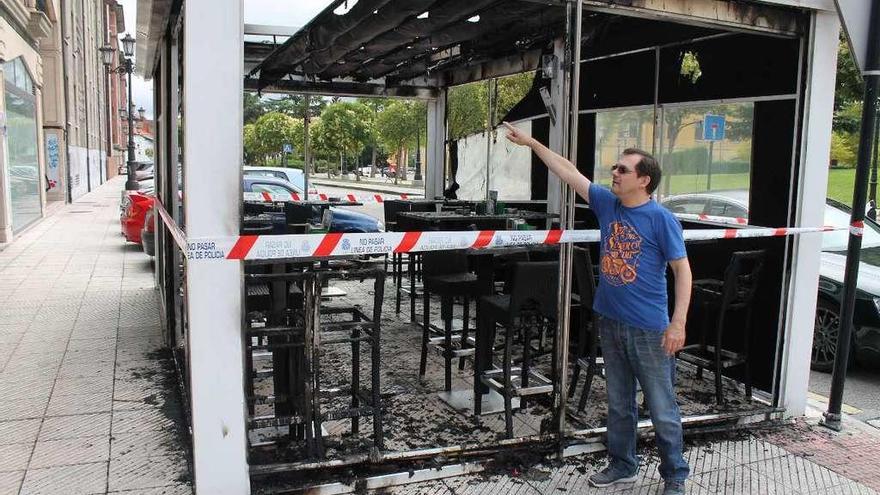 Antonio Pertierra señala los daños ocasionados por las llamas en la terraza de su cafetería.