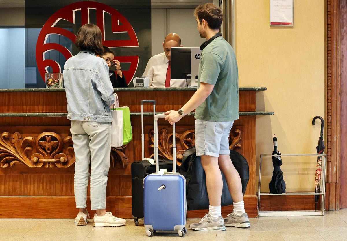 Turistes a la recepció d’un hotel, en una imatge d’arxiu.