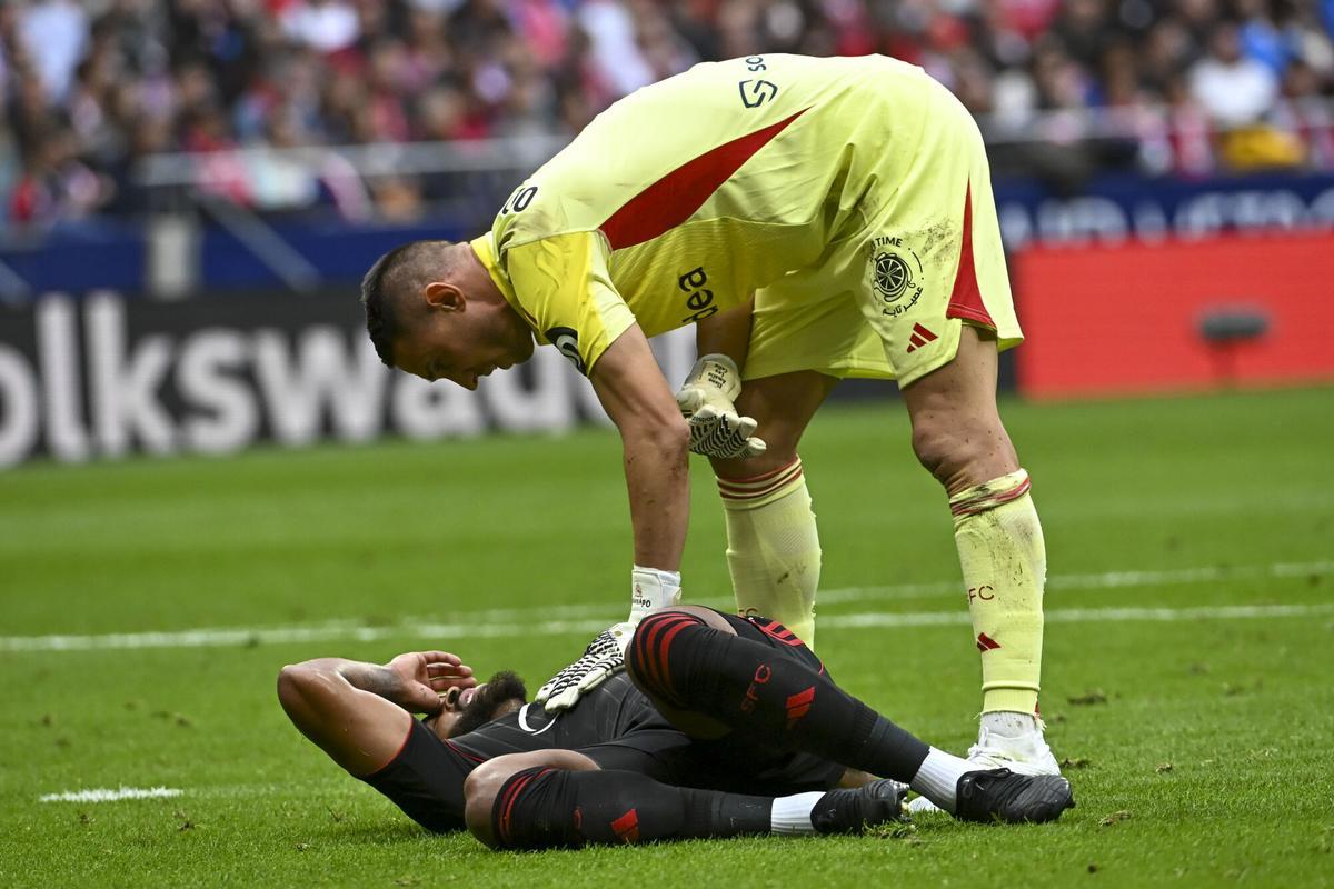 MADRID, 01/11/2025.- El portero griego del Sevilla Odysseas Vlachodimos junto a su compañero brasileño Marcao do Nascimento (en el suelo) durante partido de LaLiga entre el Atlético de Madrid y el Sevilla, este sábado en el estadio Metropolitano. EFE/ Fernando Villar. *****SOLO USO EDITORIAL/SOLO DISPONIBLE PARA ILUSTRAR LA NOTICIA QUE ACOMPAÑA (CRÉDITO OBLIGATORIO) *****