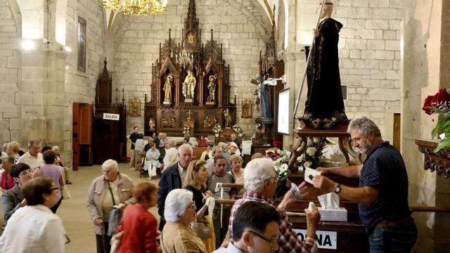 Feligreses en el interior de la iglesia de Gondomar realizando donativos a San Benito.