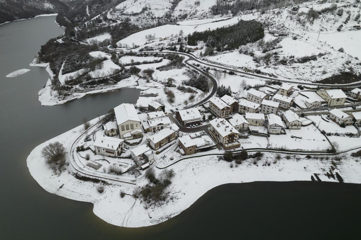 GRAFCAV4154. EUGUI, 18/01/2023.- Vista del pueblo de Eugui junto a las aguas del pantano en una jornada donde la Agencia Estatal de Meteorología ha dado alerta naranja por nieve este miércoles para toda Navarra salvo la Ribera y de nivel amarillo por riesgo de aludes para Pirineos. Según indica la Aemet, en Pirineos se puede alcanzar un espesor de nieve de 20 centímetros en 24 horas a partir de los 900-1000 metros de altitud, y en la vertiente cantábrica y el centro de la comunidad, 10 centímetros en 24 horas, por encima de los 500 metros en la vertiente cantábrica y de los 700 en el centro de la comunidad, aunque la cota de nieve estará situada en torno a los 300-400 metros. EFE/ Jesús Diges