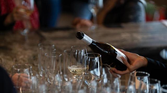Archivo - Un camarero sirve copas de vino blanco en un bar.