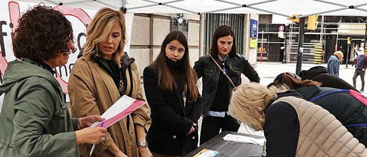 Varias personas firmando contra la cooficialidad, ayer, en Gijón. | J. Plaza