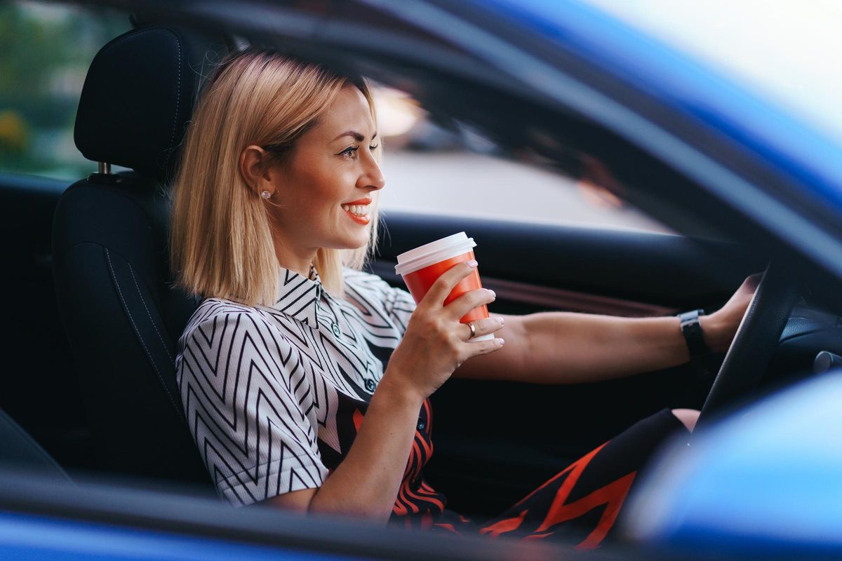 Mujer bebiendo mientras está conduciendo