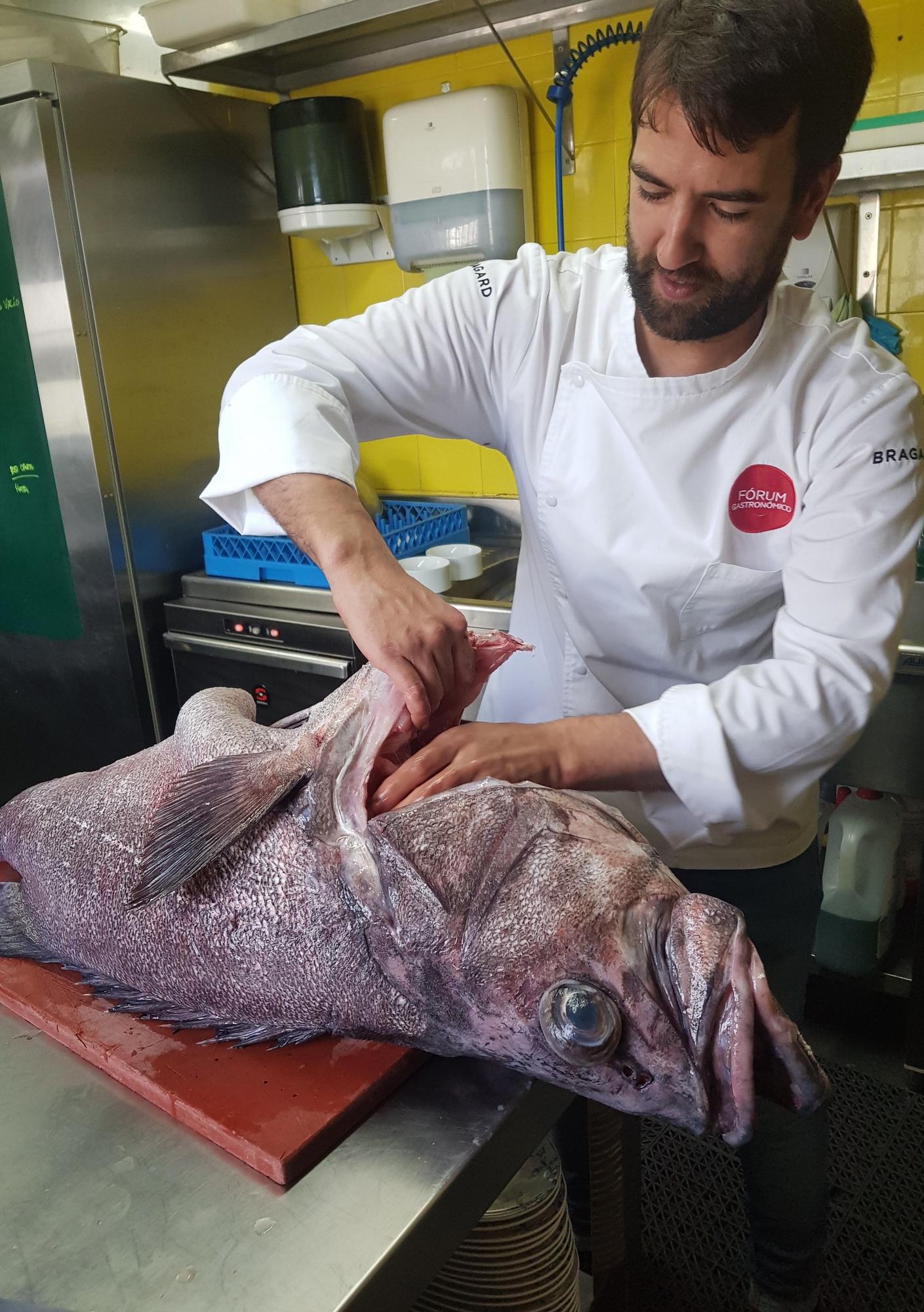 El chef grovense limpiando un mero en su cocina.