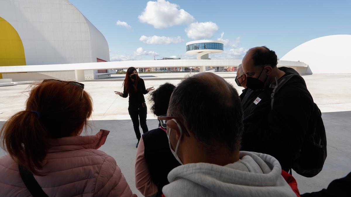 Una guía explica a unos visitantes los pormenores del Centro Niemeyer.