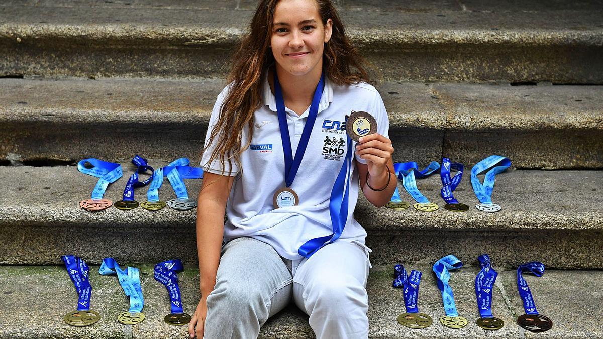 Paula Otero, con sus dos medallas europeas al cuello y las quince nacionales de exposición en las escaleras. |  // VÍCTOR ECHAVE