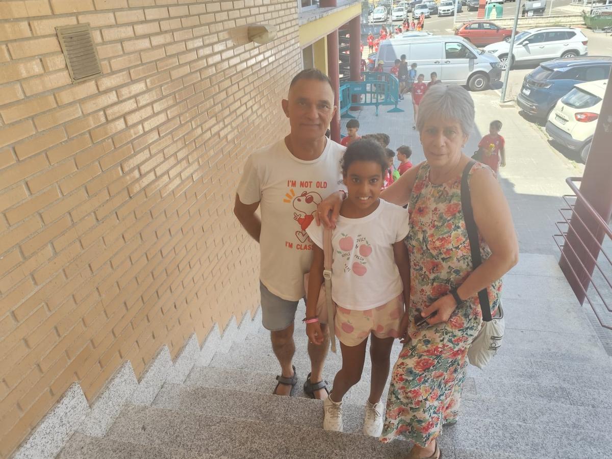 Carlos Gallego y Adi Fernández, los padres de acogida de Zeinabu, junto a la niña saharaui a la entrad de La Sindical.