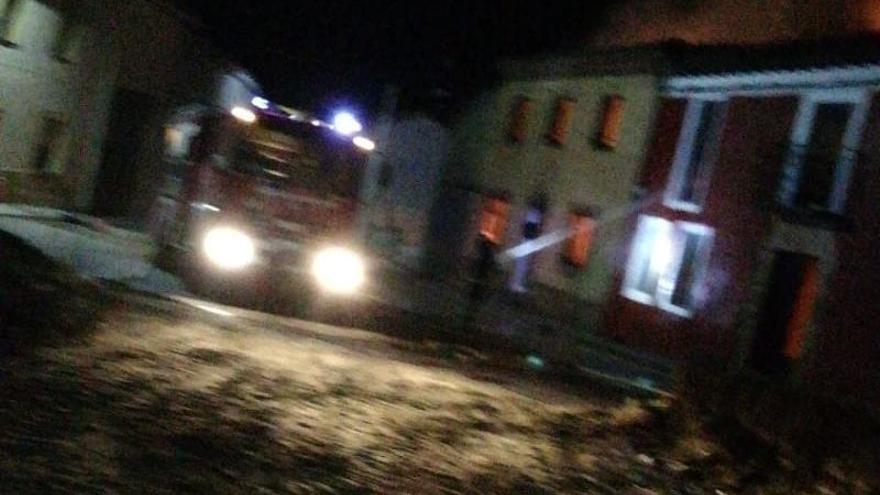 El camión de los bomberos de Benavente llega a la casas incendiadas en Prado.