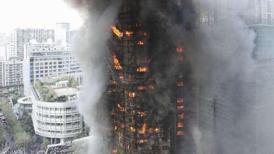 El edificio de Shanghái, envuelto en llamas y cubierto de humo. / reuters