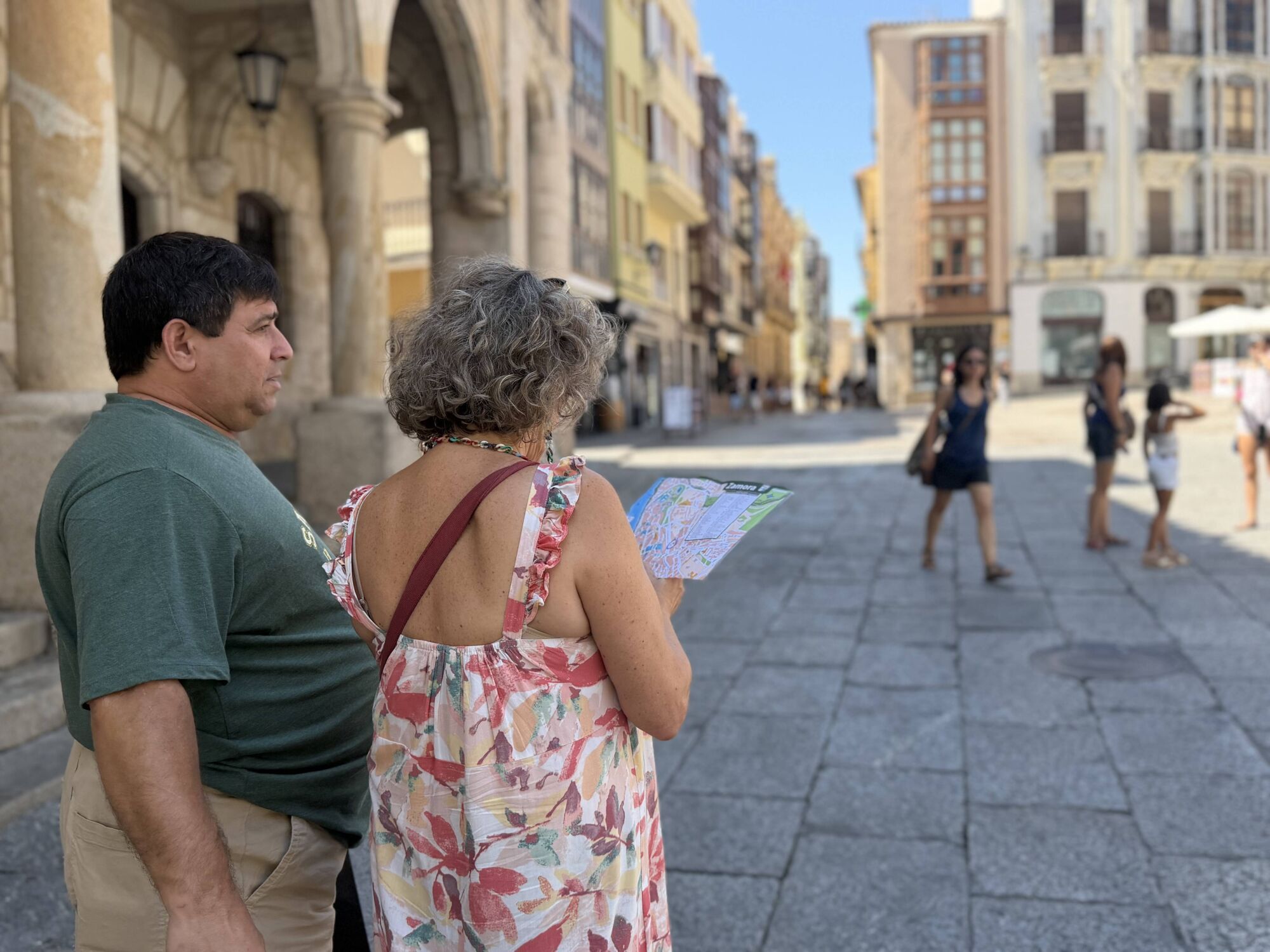 Dos turistas consultan un mapa de Zamora en la Plaza Mayor.