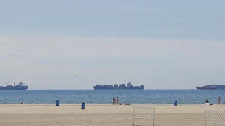 Varios buques esperan la entrada al puerto de València para descargar, ayer desde la playa de la Malva-rosa.