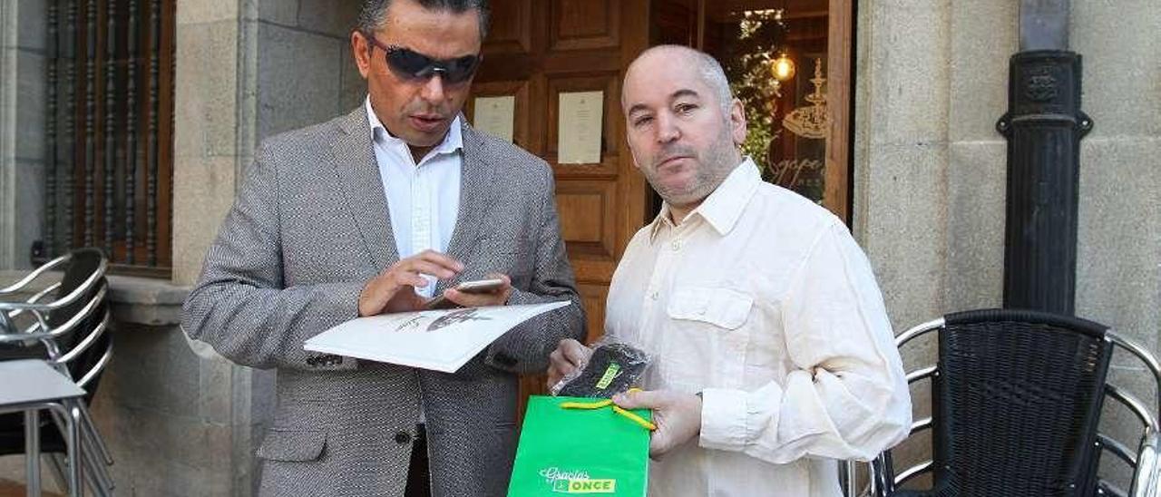 Manuel Martínez, leyendo el menú en braille con José Gómez, gerente del local. // Iñaki Osorio