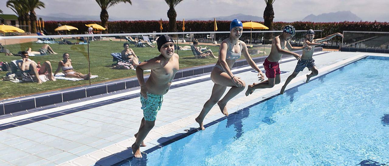 Por la izquierda, Alejandro Martínez, Carla González, Álvaro Calvillo y Diego González, ayer, lanzándose a la piscina del Centro Asturiano. | Bernabé Valle