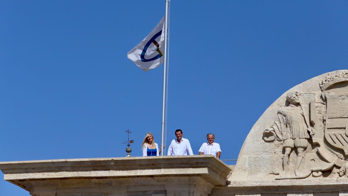 Lourdes Morales, José María Bellido y Salvador Fuentes, en la Puerta del Puente con la bandera de las Ciudades Patrimonio.
