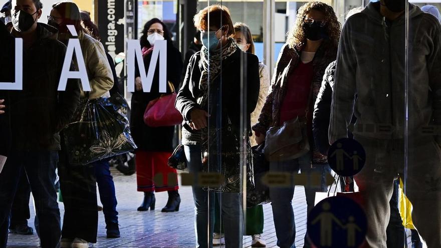 Clientes este viernes, 7 de enero, a las puertas de un establacimiento comercial en Málaga.