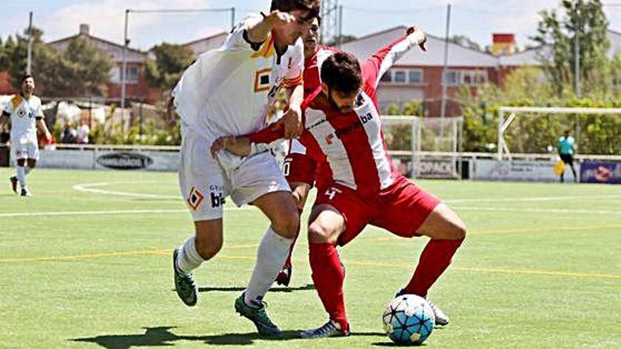 El blanc-i-vermell Gerard Martínez protegeix la pilota davant la presència d&#039;un defensor local