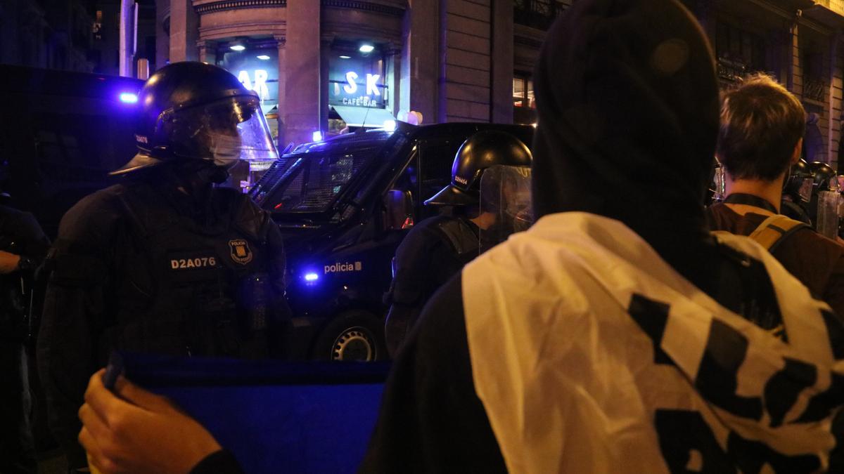 Una persona subjecta una pancarta davant d&#039;agents dels Mossos d&#039;Esquadra a la Via Laietana