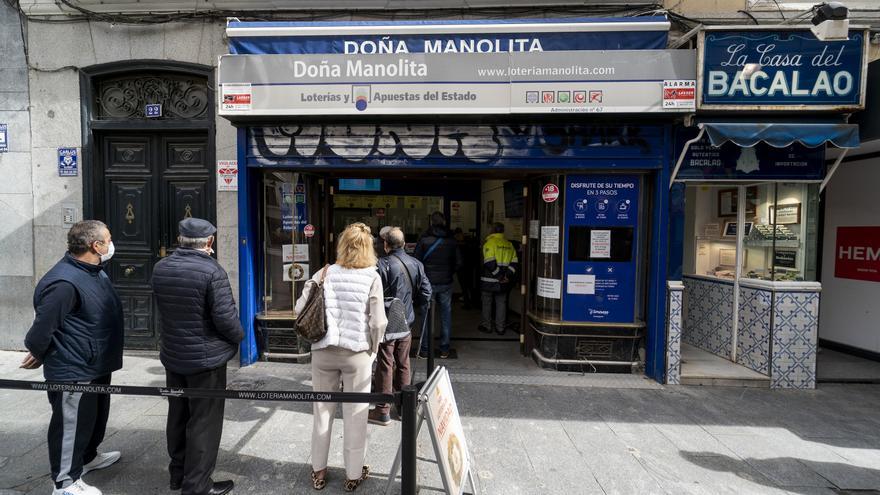 Archivo - Un grupo de personas esperan a las puertas de la administración de lotería Doña Manolita
