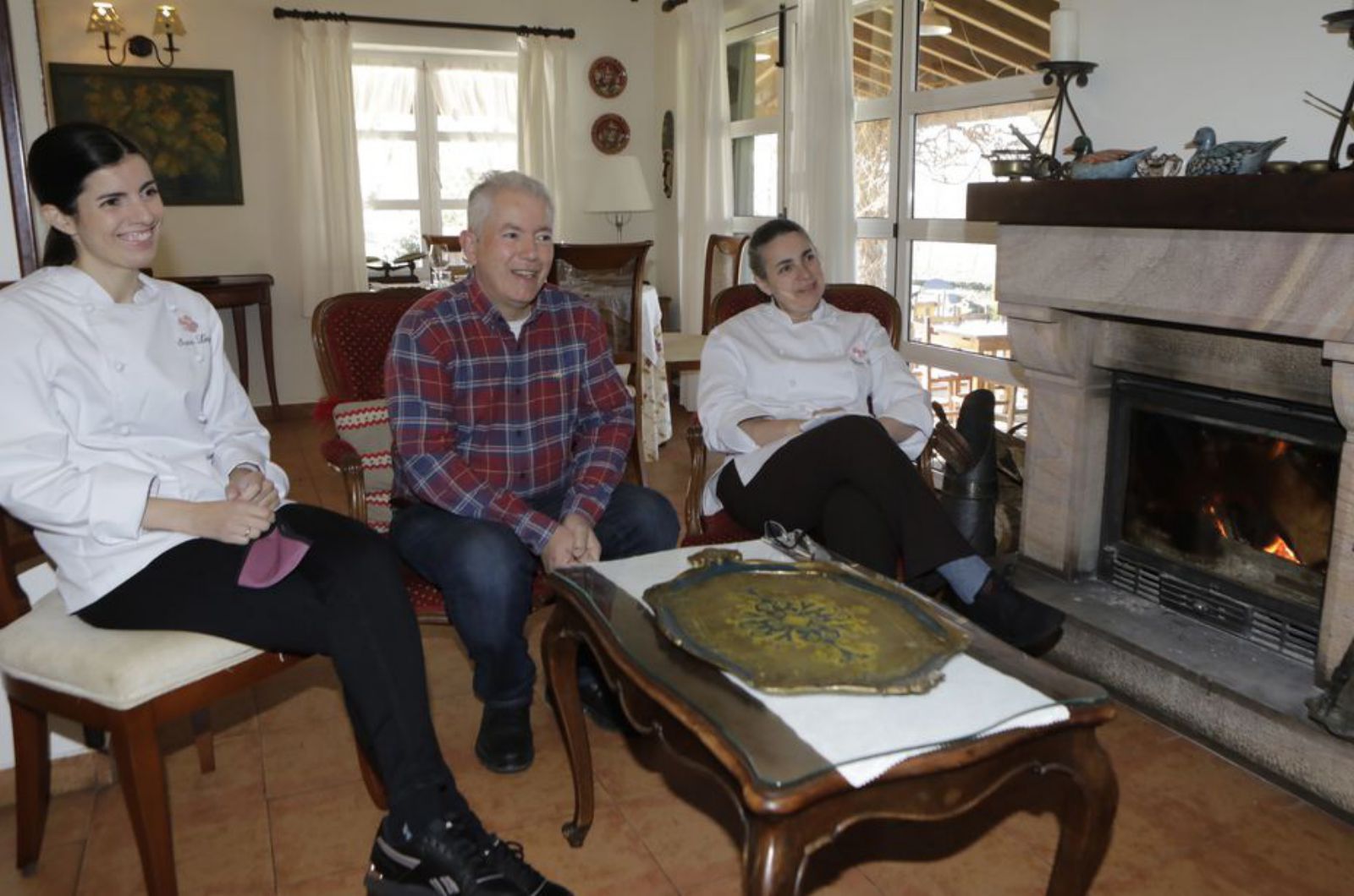 Sara López Corral, con sus padres, Juan e  Yvonne, en uno de los salones de Casa Telva, junto a la chimenea. | FERNANDO  RODRÍGUEZ