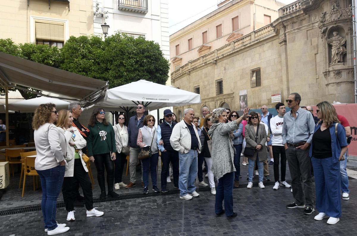 Turistas nacionales durante una visita guiada por el entorno de la Catedral de Murcia.