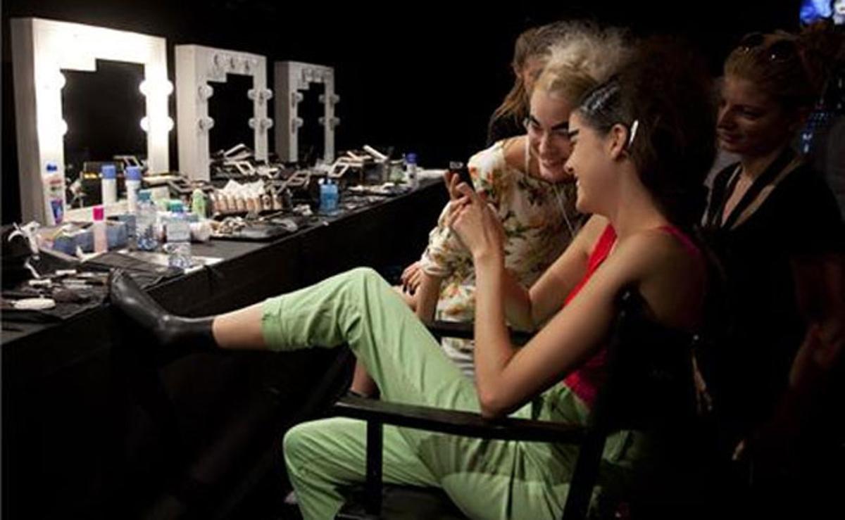 Dues models es diverteixen en els preparatius previs a la desfilada de la col·lecció primavera/estiu de la dissenyadora de moda Patrick Mohr a la Setmana de la Moda de Berlín (Alemanya).