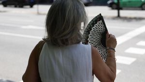 Una mujer se abanica para intentar mitigar las altas temperaturas que se registran en Madrid, este jueves.