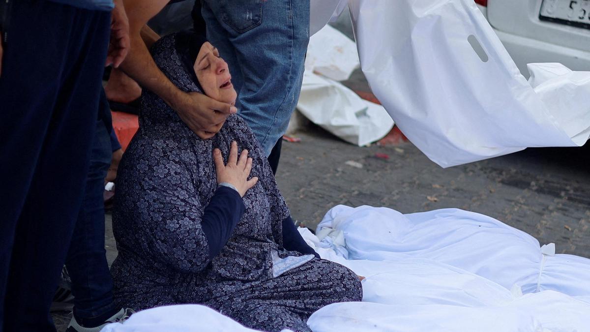 Familiares reaccionan junto a los cuerpos de palestinos muertos en ataques israelíes, en un hospital de Gaza.