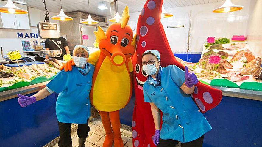 Dos empleadas del Mercat Nou se hacen una foto con las dos mascotas de la iniciativa.