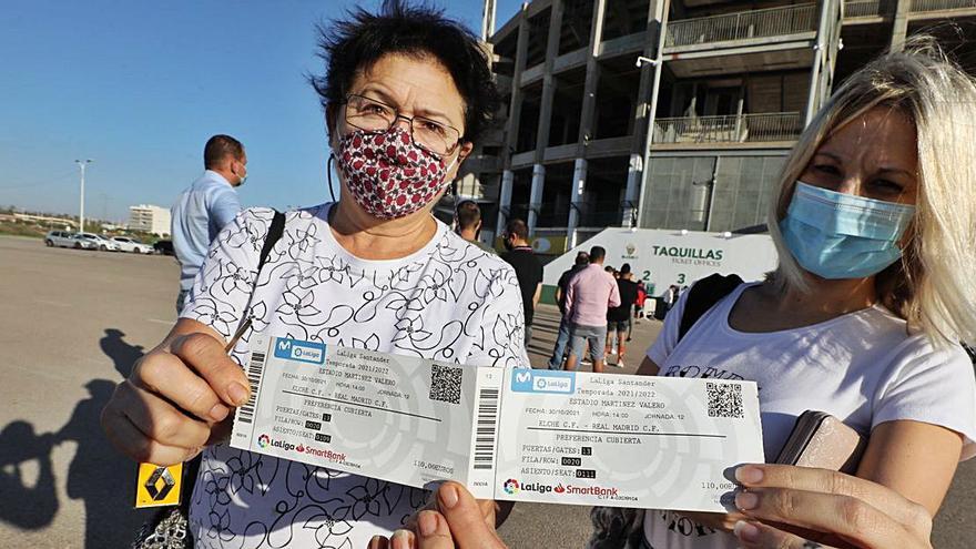 Dos aficionadas muestran sus entradas recién compradas ayer a primera hora. | ANTONIO AMORÓS