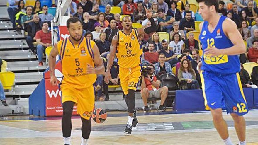 DJ Strawberry, al fondo, sube el balón y marca jugada en el partido Herbalife-Maccabi en el Arena.