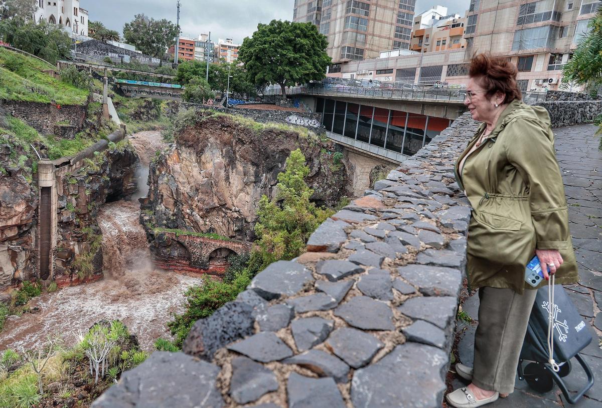 Una mujer observa la crecida del Barranco de Santos en Santa Cruz de Tenerife.