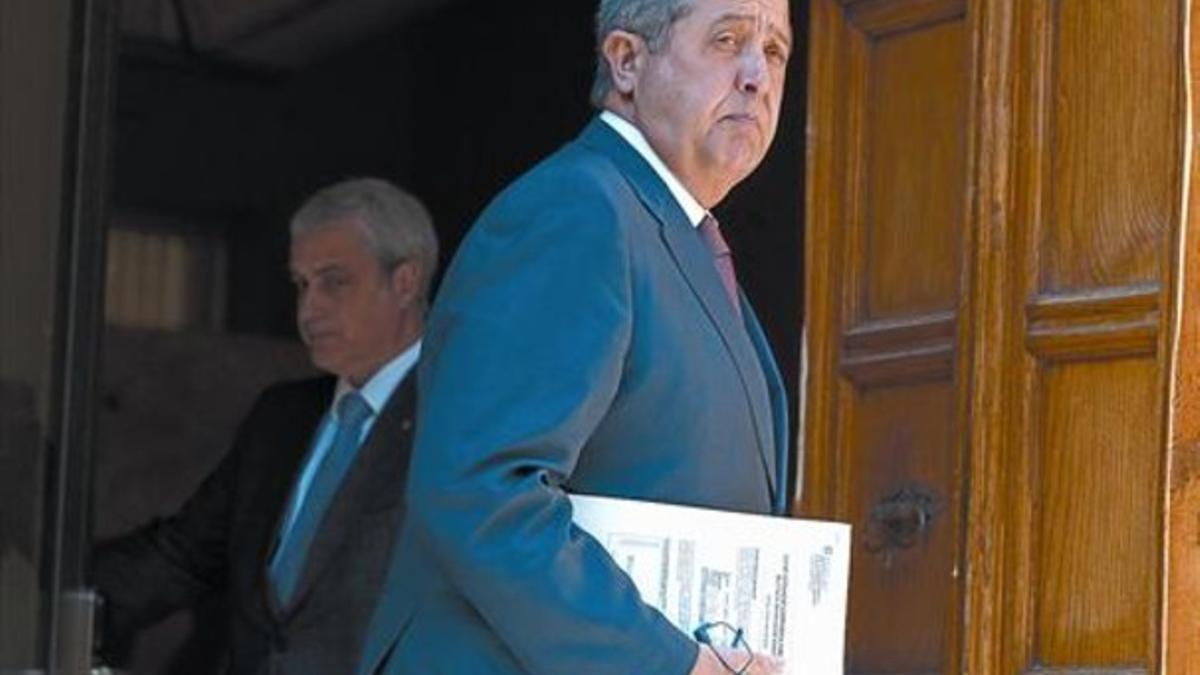 El 'conseller' de Empresa, Felip Puig, pasa ante el titular de Justícia, Germà Gordó, el 13 de marzo del 2012, en el Palau de la Generalitat.