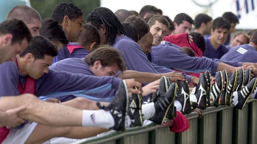 El grueso de jugadores del Deportivo hace estiramientos en una de las vallas de A Magdalena en Vilalba en la pretemporada de 2001. |  // LOC