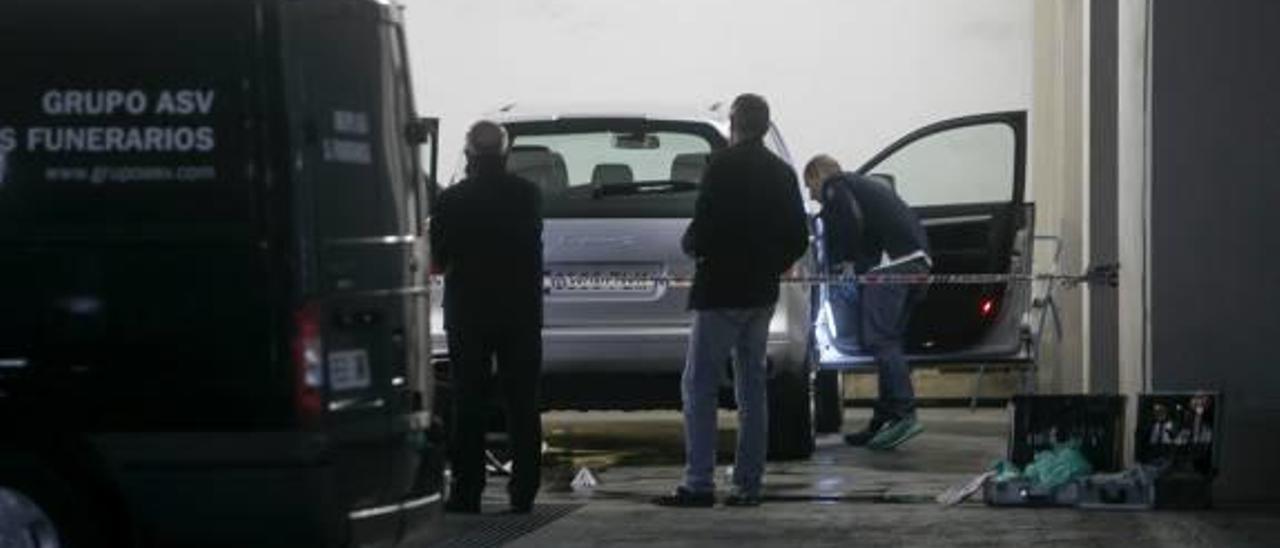 La Policía, inspeccionando el coche de la víctima.