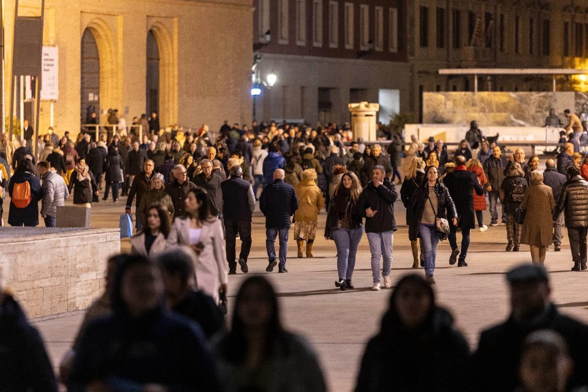 Un grupo de paseantes durante la noche por la plaza del Pilar de Zaragoza.