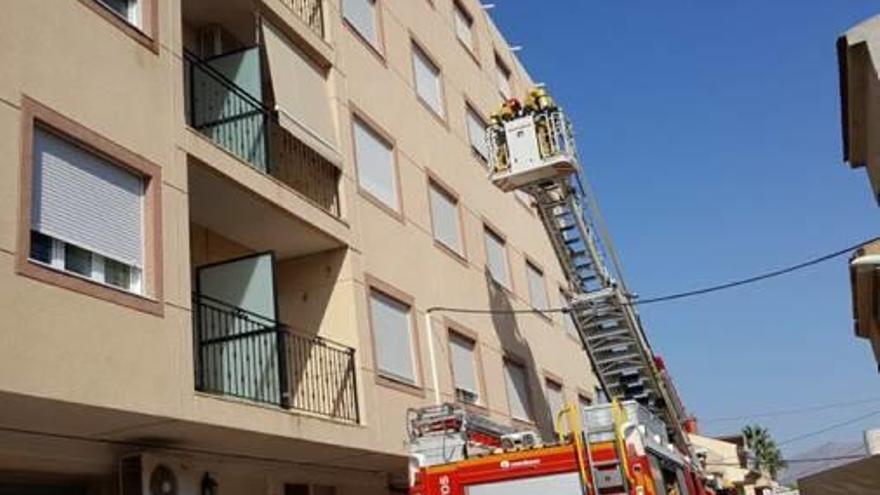 Bomberos acceden con la escalera hasta la cuarta planta.