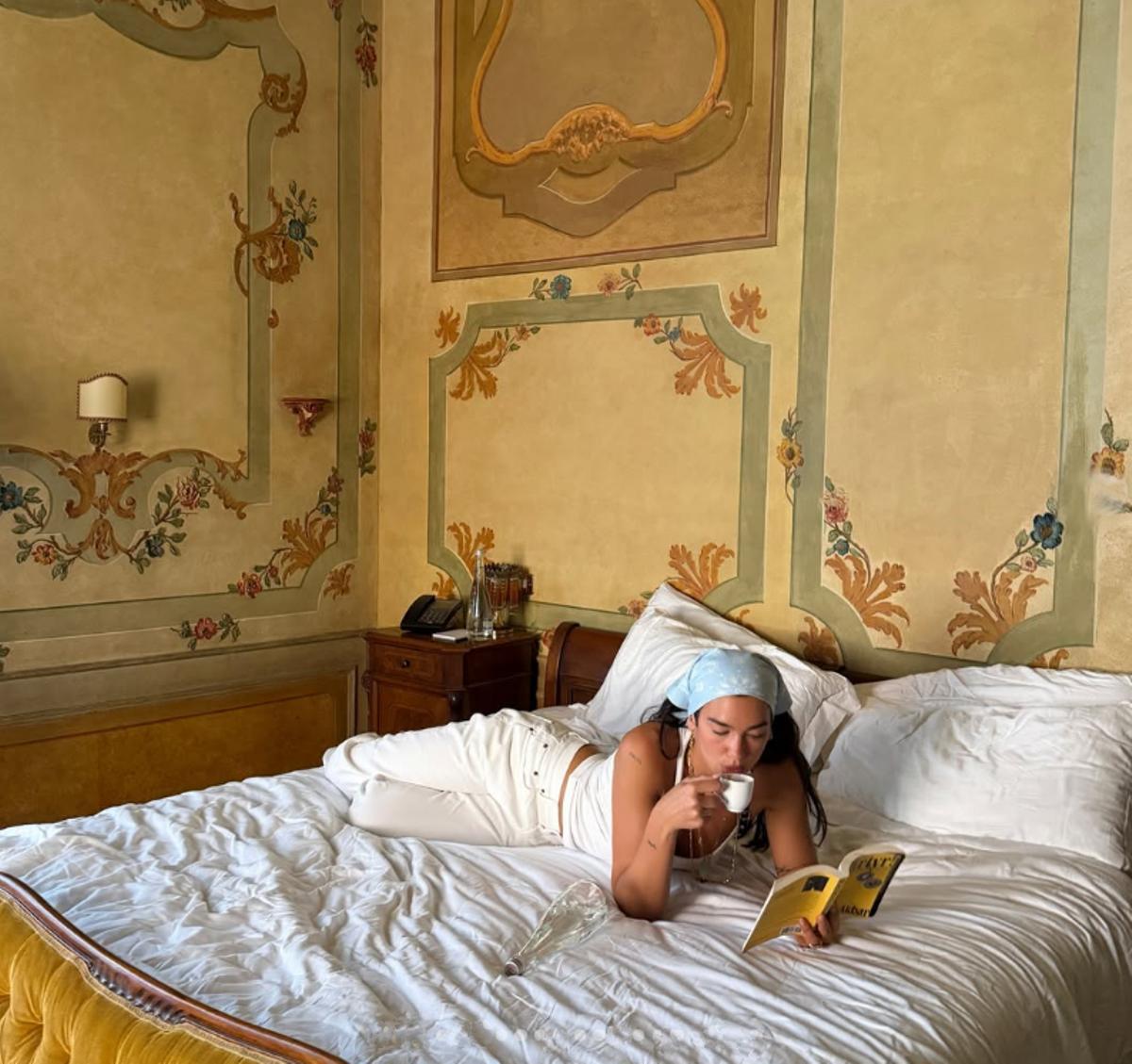 Dua Lipa, leyendo en la habitación de un hotel en Italia, durante su luna de miel, en junio.