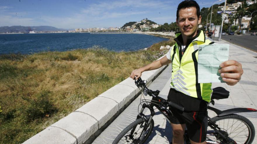 Antonio Navas, con su bicicleta, muestra la multa en el mismo lugar donde se la puso el policía.