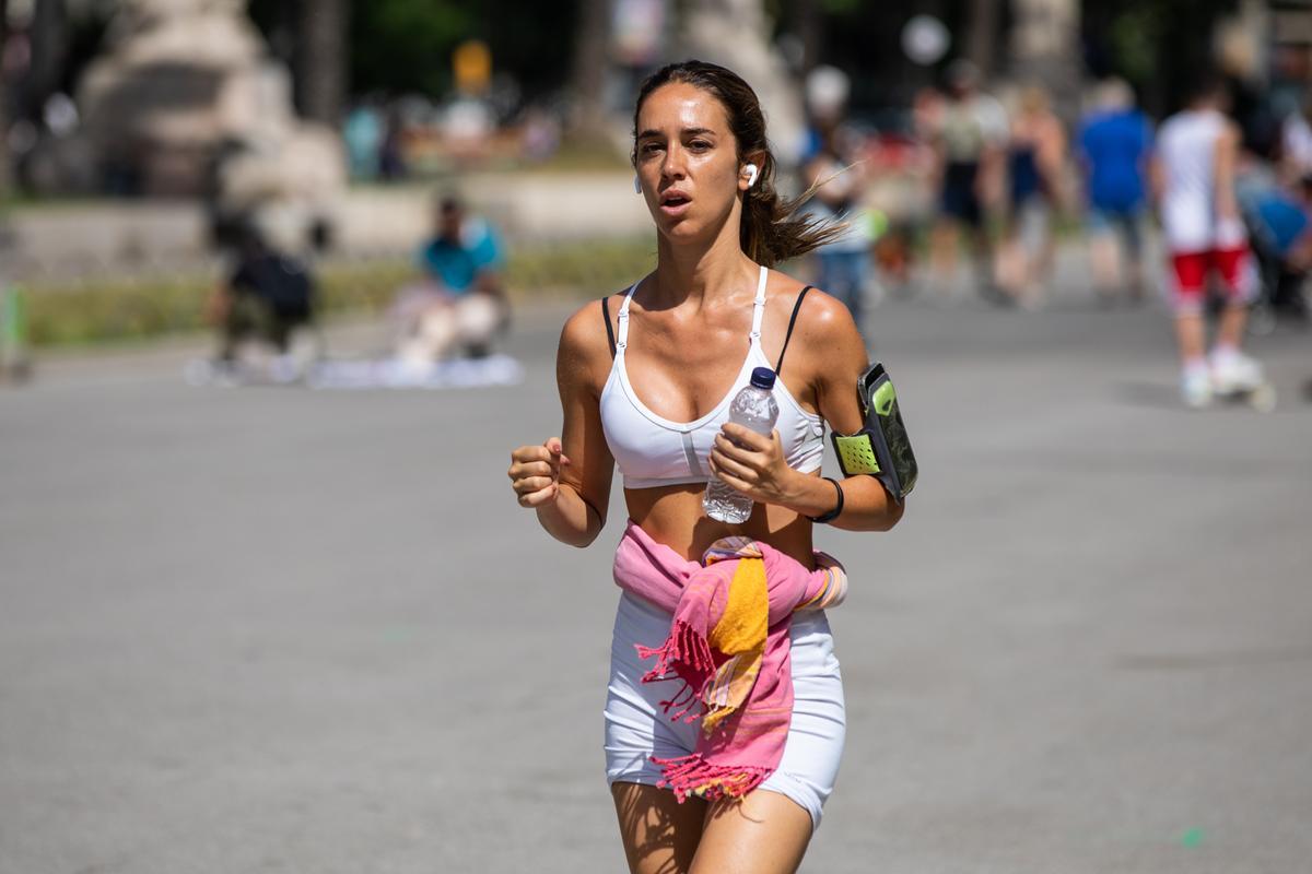 Una chica con una botella de agua, en el paseo de Lluís Companys de Barcelona.