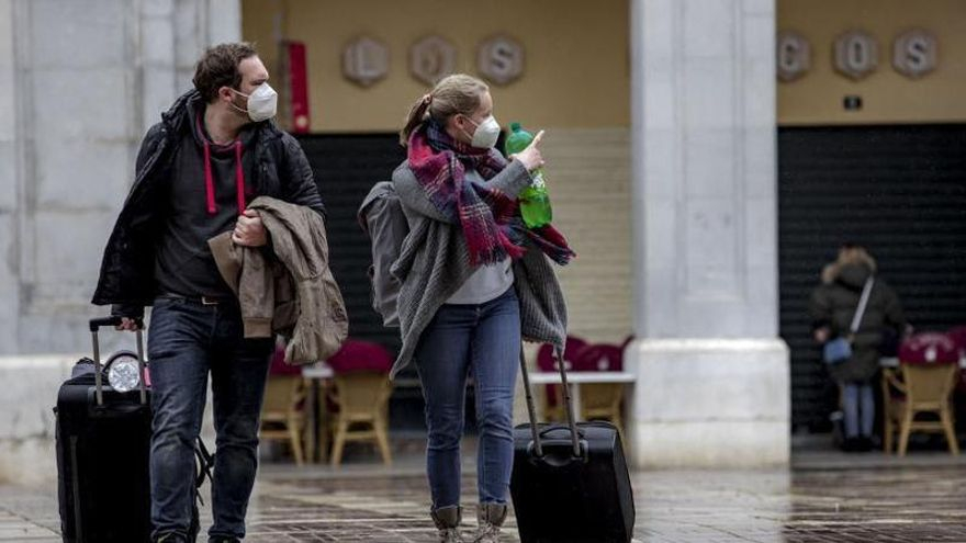 Turistas arrastrando maletas en la Plaza Major de Palma en busca de un piso turístico.