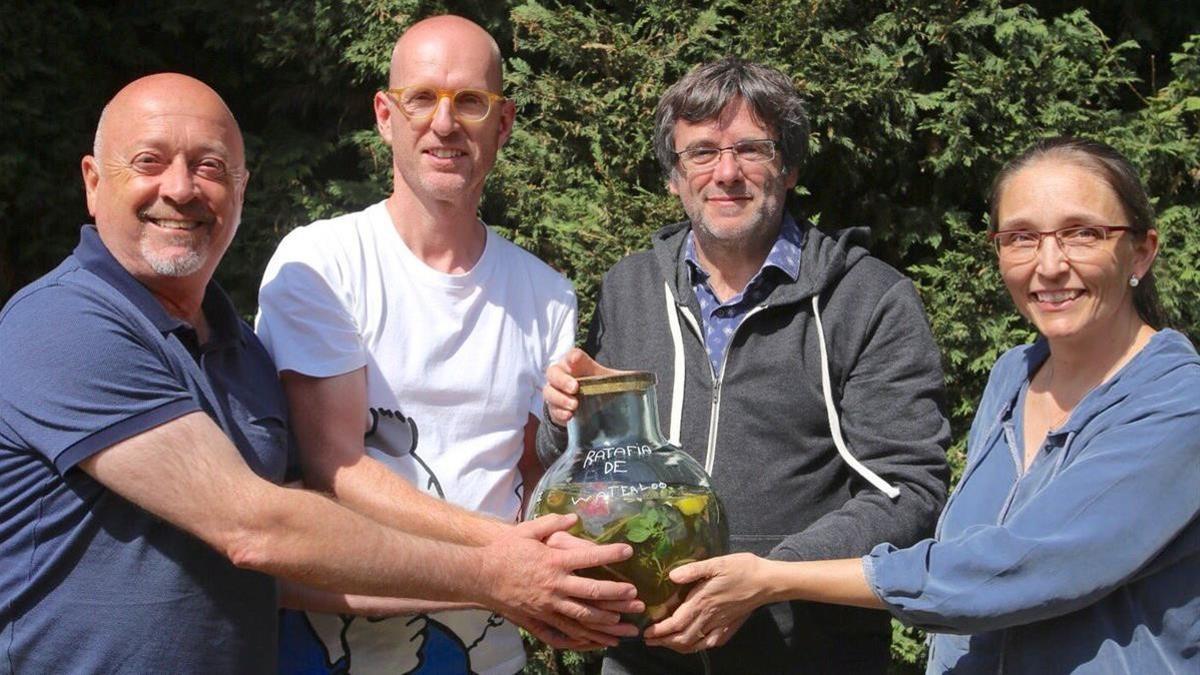 Puigdemont muestra una botella con la ratafía de Waterloo.