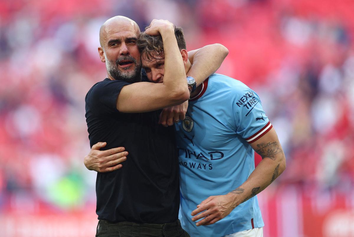 Pep Guardiola se abraza con John Stones en un partido con el Manchester City.