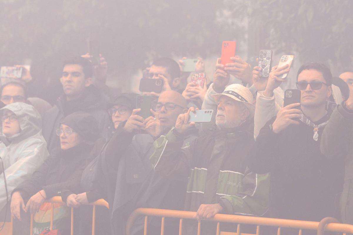 Primera fila de la "mascletà" con espectadores cubiertos por el humo de la disparada.