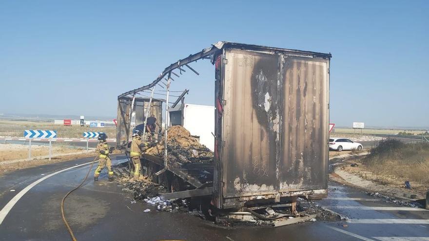 Los bomberos realizando tareas de refresco de la carga, completamente arrasada por las llamas.