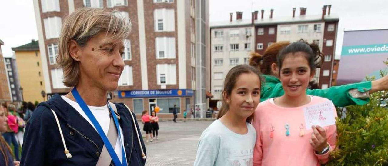 Mercedes Rodríguez, animadora sociocultural, con tres niñas en el árbol de los deseos.