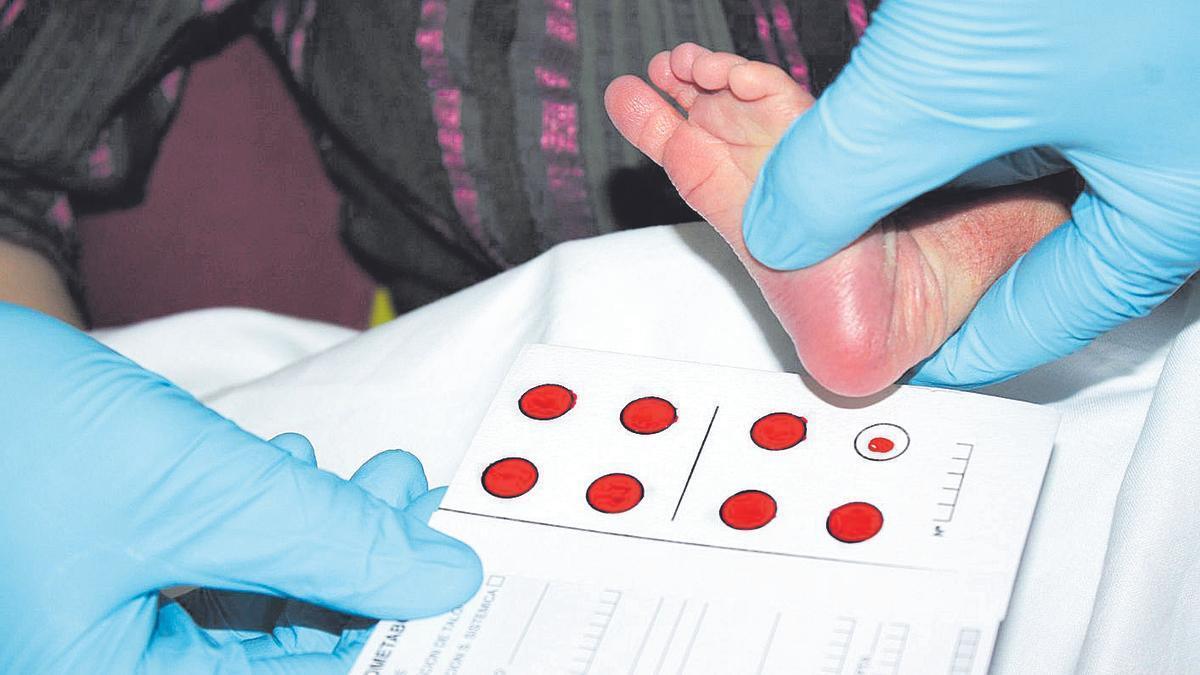Una sanitaria realiza la prueba del talón a un recién nacido.