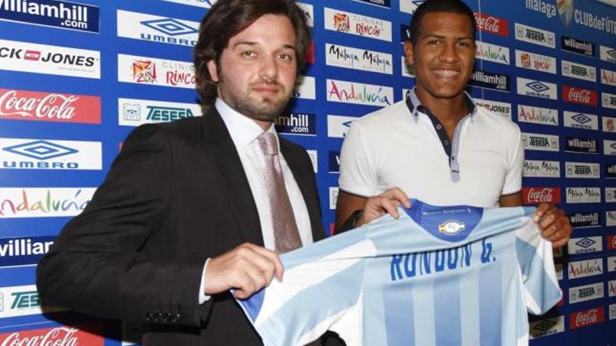El futuro vicepresidente del club sostiene la camiseta del Málaga con el último fichaje malaguista.