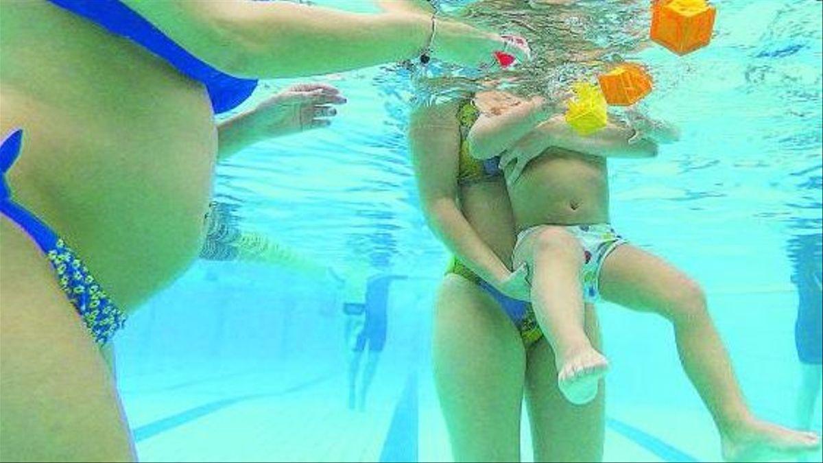 Mujeres con bebés en una piscina.